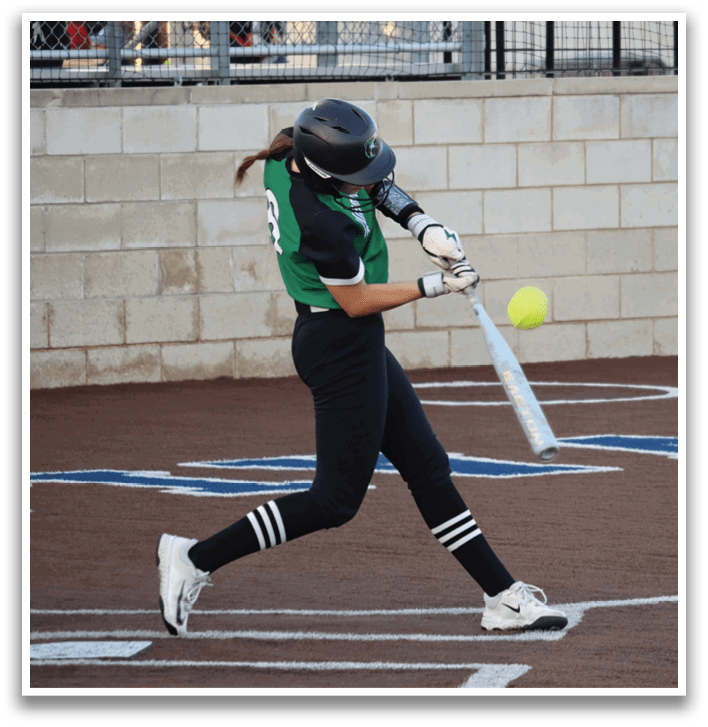 A woman in a black and green shirt is swinging a bat at a ball. Contenido generado con IA