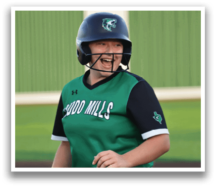 A woman wearing a green and black baseball uniform is smiling and walking on a field. Contenido generado con IA