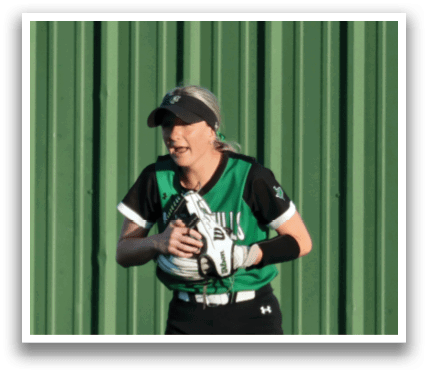 A woman in a black and green shirt is holding a softball. Contenido generado con IA