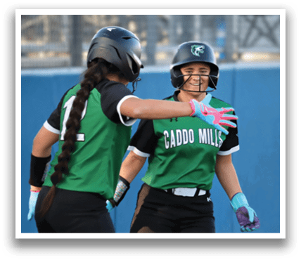 Three female softball players wearing green and black uniforms are standing on a field. They are smiling and laughing, with one of them holding a bat. Contenido generado con IA