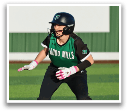 A female baseball player is standing on the field wearing a helmet and holding a glove. Contenido generado con IA