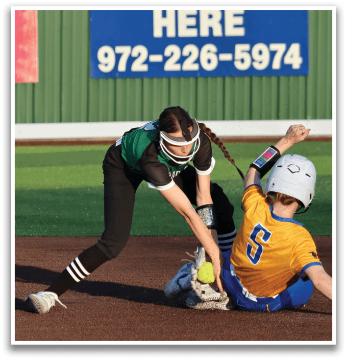 Two girls playing softball, one sliding into a base. Contenido generado con IA