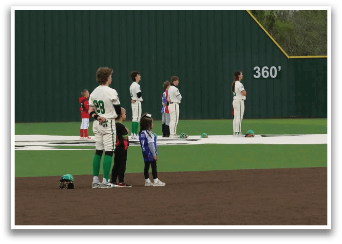 A group of children are standing on a baseball field, some wearing baseball uniforms. Contenido generado con IA