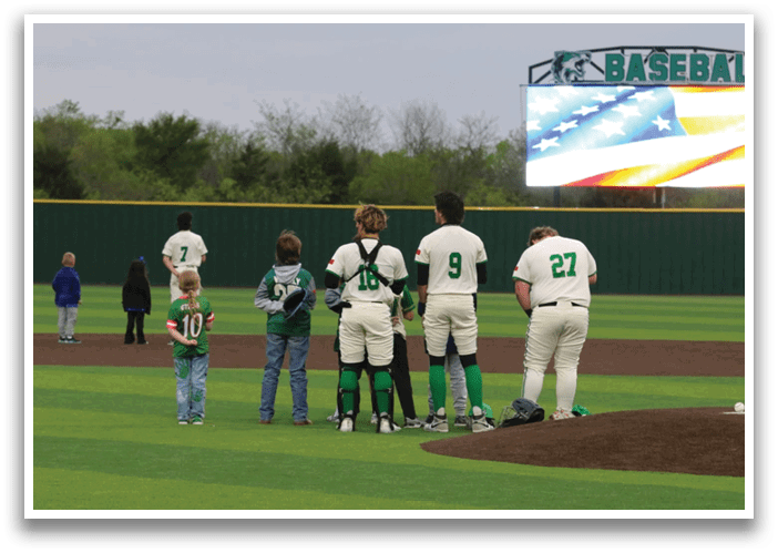 A group of baseball players and a young boy stand on a baseball field. Contenido generado con IA