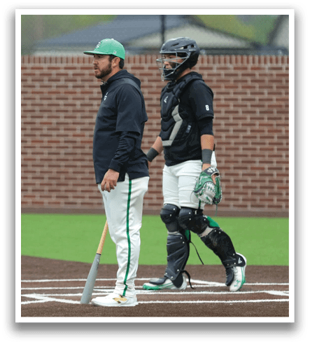 Two baseball players standing on a field, one holding a bat and the other wearing a helmet. Contenido generado con IA