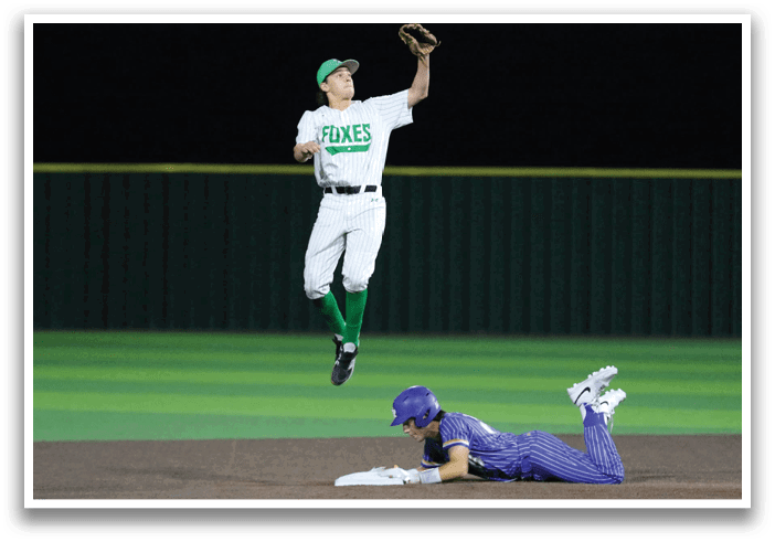 A baseball player is leaping in the air to catch a ball while another player is sliding into home base. Contenido generado con IA