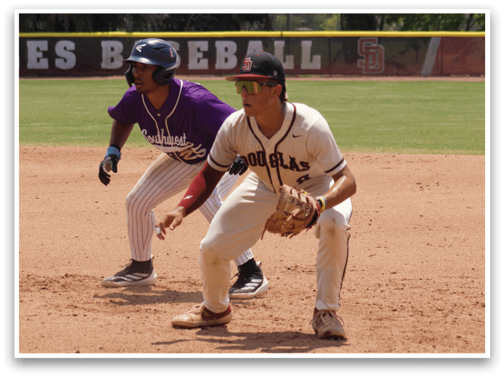 A baseball player in a white uniform is crouching on the field. Description generated by AI
