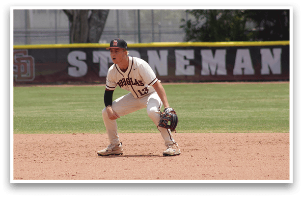 A baseball player in a white uniform is crouching on the field. Description generated by AI