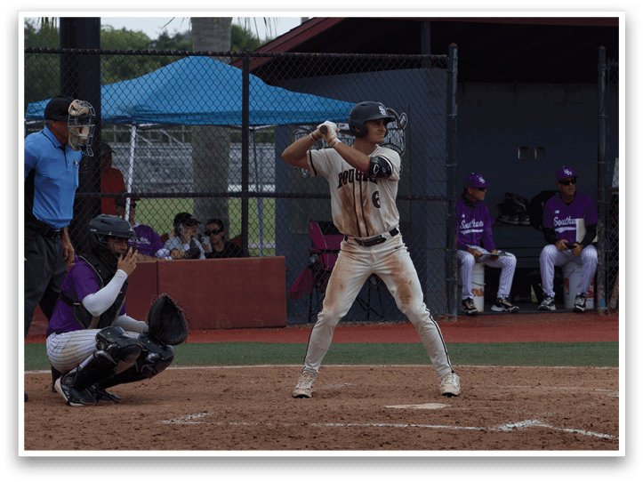 A baseball player is holding a bat, ready to swing. Description generated by AI