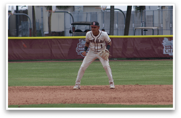 A baseball player in a white uniform is standing on the field. Description generated by AI