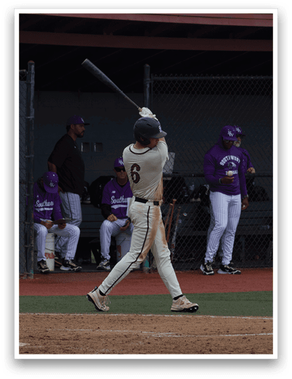 A baseball player is swinging a bat on a field. Description generated by AI