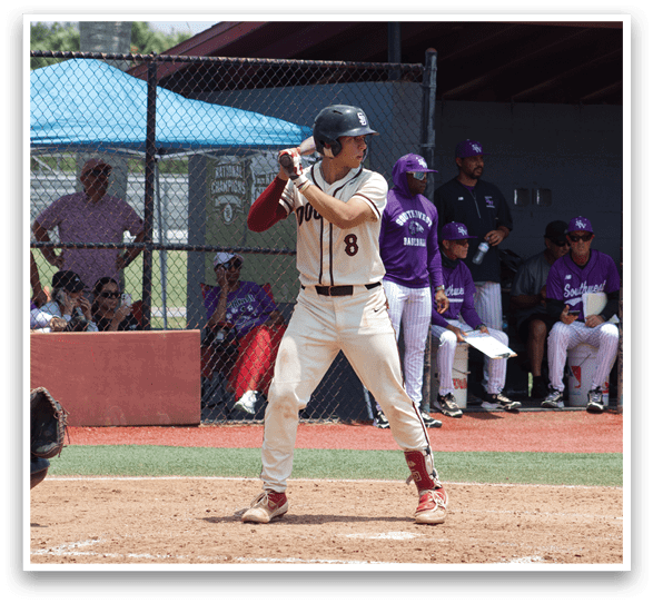 A baseball player in a white uniform holding a bat. Description generated by AI