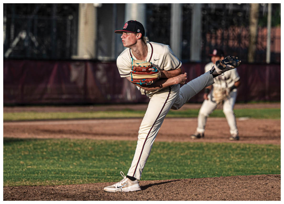 A baseball player in a white uniform is pitching a ball. Description generated by AI