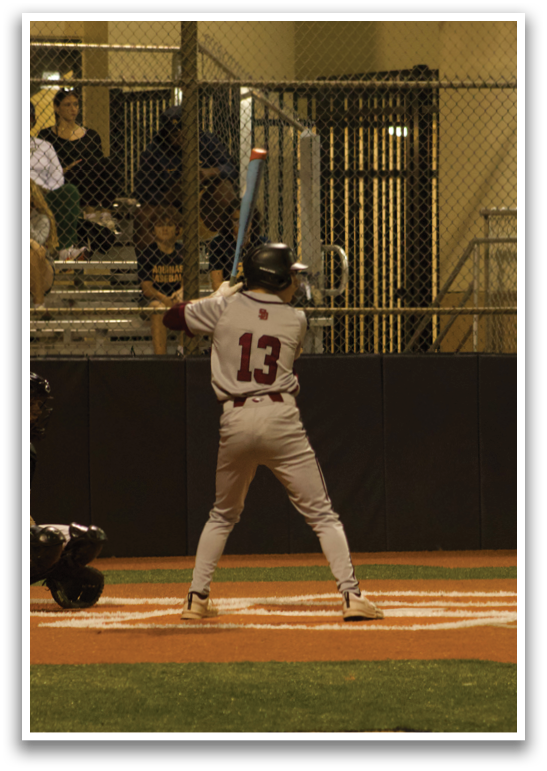 A baseball player is at bat, holding a bat and preparing to swing. AI generated content
