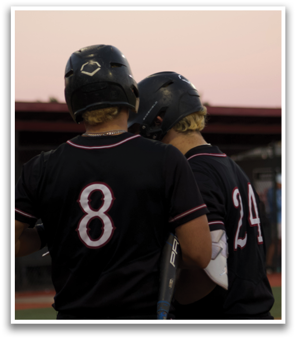 Two baseball players wearing black jerseys and helmets are talking to each other. AI generated content