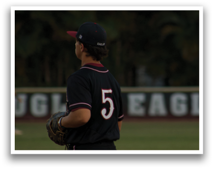 A baseball player wearing a black shirt and red hat stands on a field. AI generated content