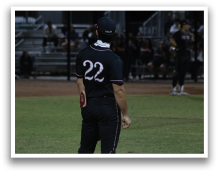A baseball player wearing a black shirt and red hat stands on a field. AI generated content