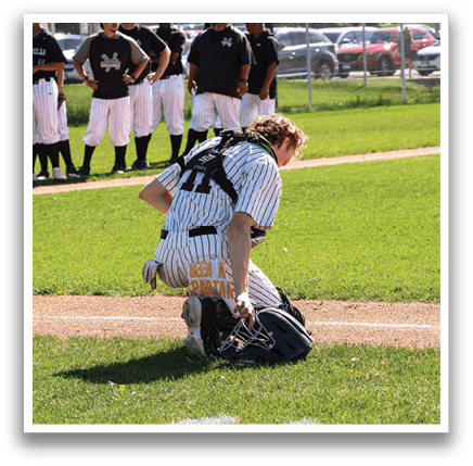 A baseball player is kneeling on the ground with his glove on, ready to catch the ball. AI generated content