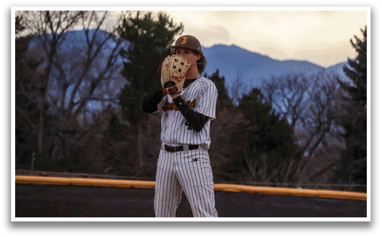 A baseball player wearing a black and white uniform is standing on a field, holding a baseball in his glove. AI generated content