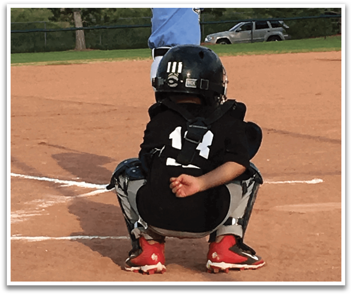 A baseball player is sitting on the ground with his legs crossed, wearing a catcher's mitt. AI generated content