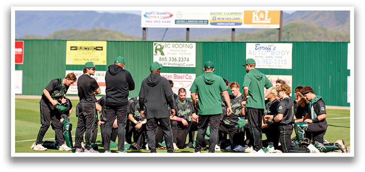 A group of baseball players huddled together on the field, wearing green and black uniforms. AI generated content