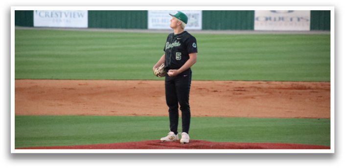 A baseball player is standing on the pitcher's mound, wearing a black shirt and holding a baseball glove. AI generated content