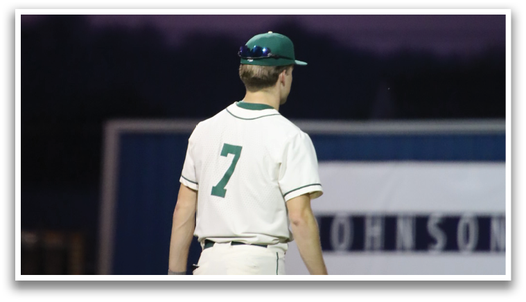 A baseball player wearing a green and white uniform is walking on the field. AI generated content