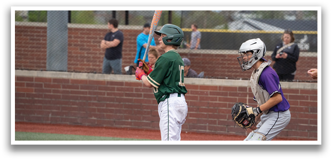 A boy in a green shirt is holding a baseball bat, ready to swing. AI generated content