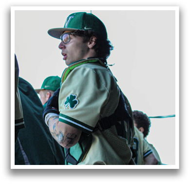 A baseball player wearing a green and white uniform stands on the field. AI generated content