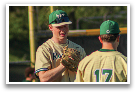Two baseball players wearing green and white uniforms are talking to each other. One player is holding a baseball glove. AI generated content