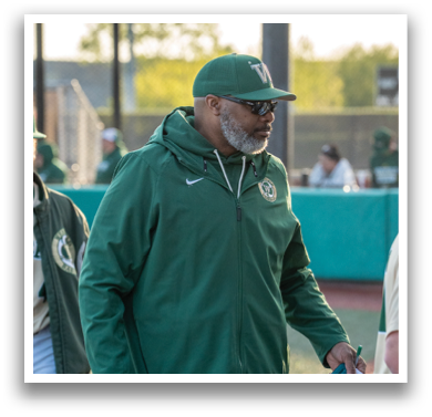 A man wearing a green jacket and a baseball cap is walking on a field. AI generated content