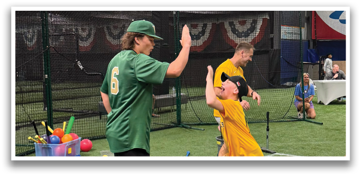 A man and a boy are playing baseball in a batting cage. The man is giving the boy a high five. AI generated content