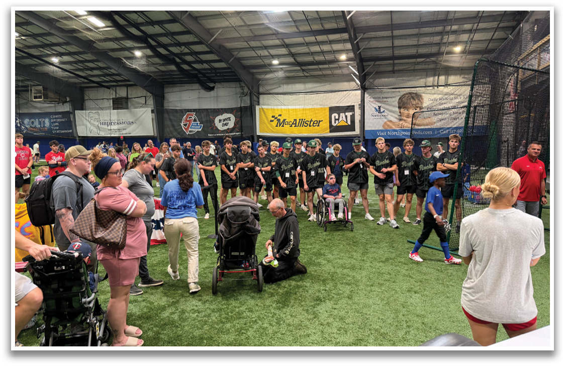 A group of people are gathered in a field, with some standing and others sitting. A young boy is holding a baseball bat, and a sports ball is visible in the scene. The people are watching the boy, possibly waiting for their turn to play or participate in the game. AI generated content