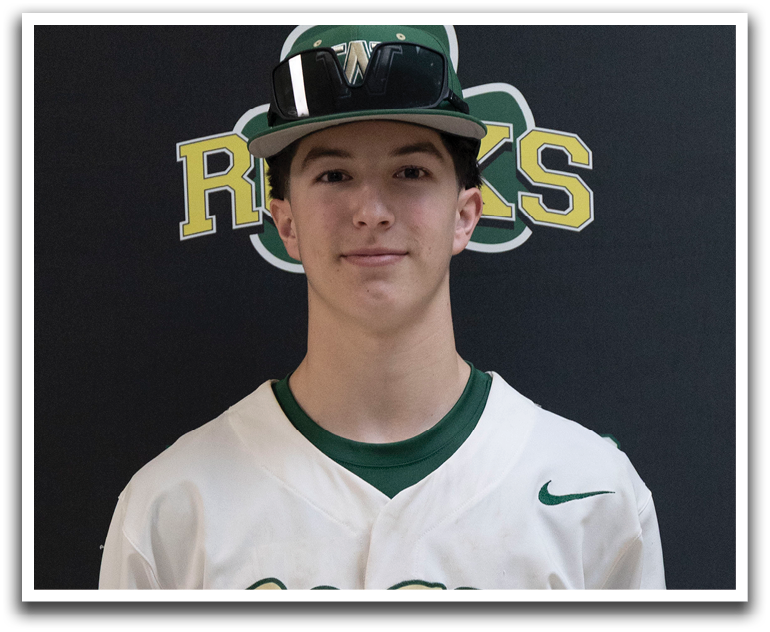 A young man wearing a baseball uniform with the word Rocks on the front. Description generated by AI