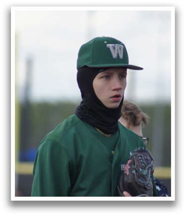A baseball player wearing a green and white uniform. Description generated by AI
