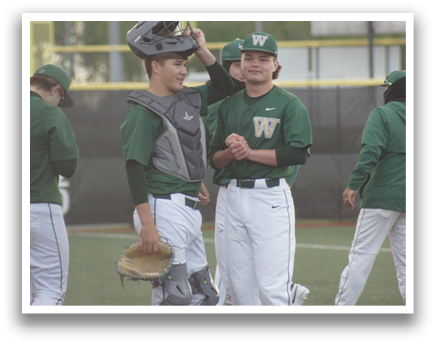 A group of baseball players wearing green and white uniforms. Description generated by AI