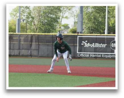 A baseball player in a green shirt and white pants is standing on the field. Description generated by AI