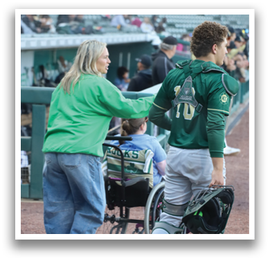A man in a green shirt and white pants is bending over to talk to a woman. Description generated by AI