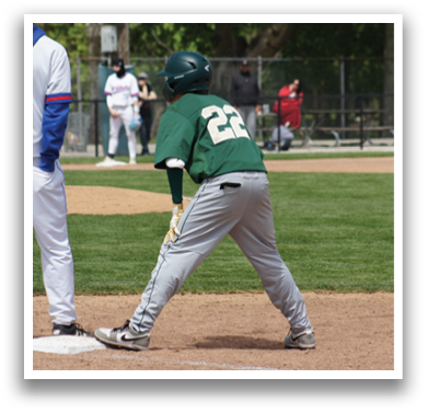 A baseball player wearing a green and white uniform is at home base. Description generated by AI