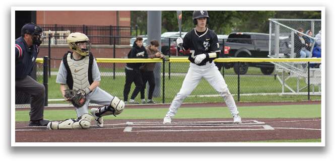 A baseball player is holding a bat and standing at home plate. Description generated by AI