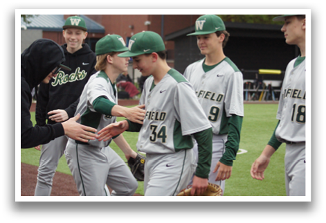 A group of baseball players wearing green and white uniforms. Description generated by AI