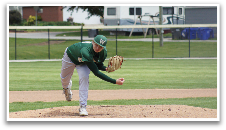 A baseball player in a green shirt and gray pants is pitching a ball. Description generated by AI