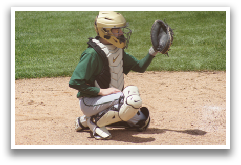A baseball catcher in a green and white uniform. Description generated by AI
