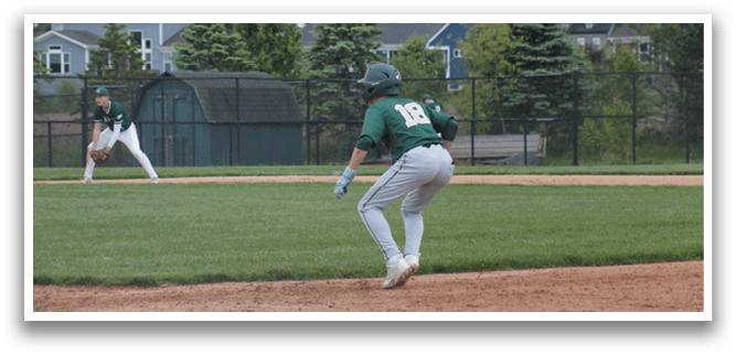 A baseball player wearing a green and white uniform is running towards a base. Description generated by AI