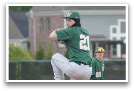 A baseball player in a green shirt and white pants is pitching a ball. Description generated by AI