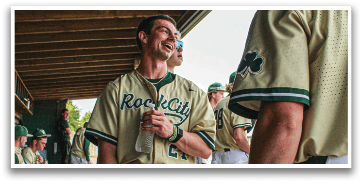 A man wearing a baseball uniform is laughing. Description generated by AI