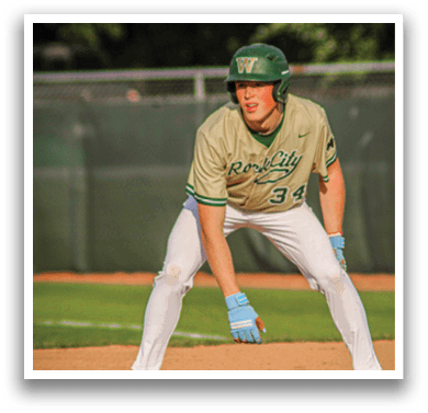A baseball player wearing a green helmet and white uniform. Description generated by AI