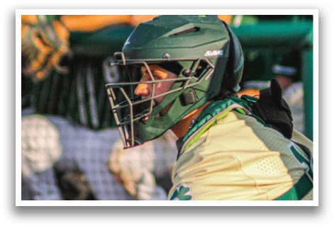 A baseball player wearing a green helmet and green pads. Description generated by AI