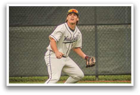 A baseball player in a white uniform and a brown hat is standing on a grass field. Description generated by AI