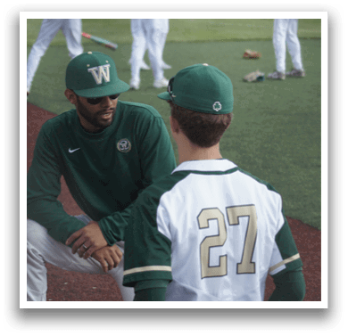 A man and a boy are talking on a baseball field. Description generated by AI